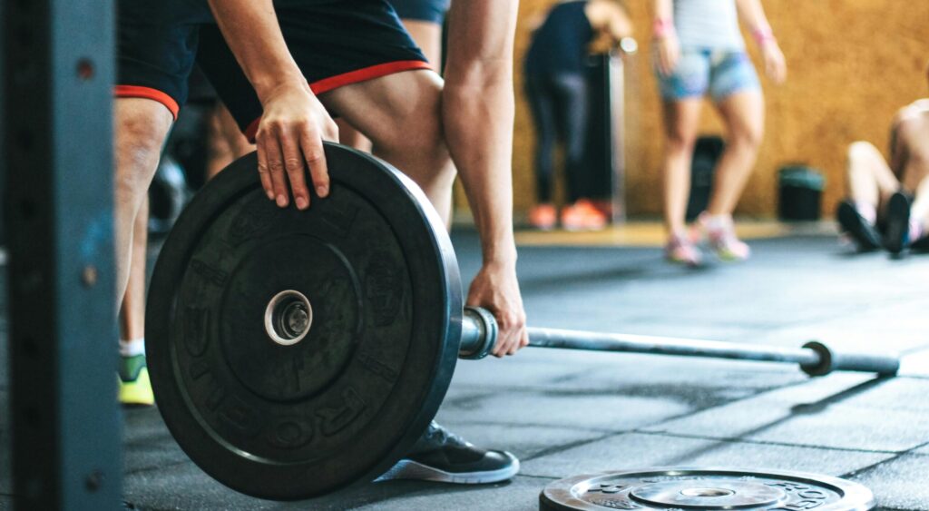 Focused weightlifting session in a gym with diverse athletes participating indoors.